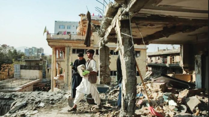 Taliban Two young men, one in all black holding a spade and another in white carrying a brick, stand amid the rubble of a destroyed building in Kabul. EPA