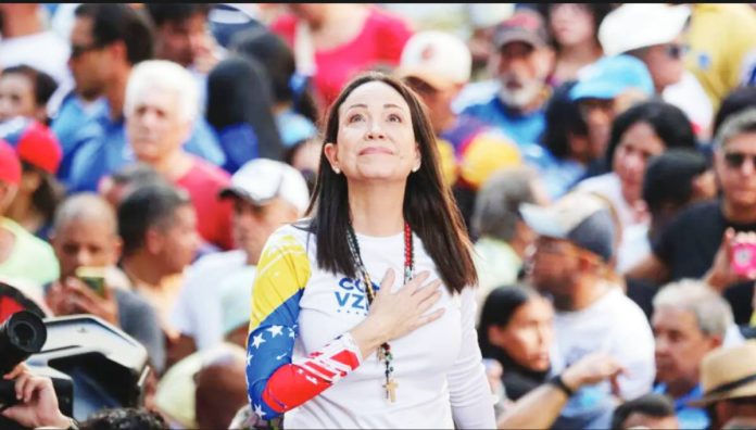 Venezuela María Coria Machado holds one hand to her chest, as a crowd stands behind her. GETTY IMAGES