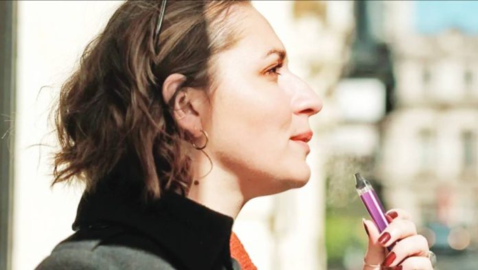 A young woman vapes. As of February this year, at least 86 million e-cigarette users were adults, mostly in high-income countries., according to the World Health Organization. GETTY IMAGES
