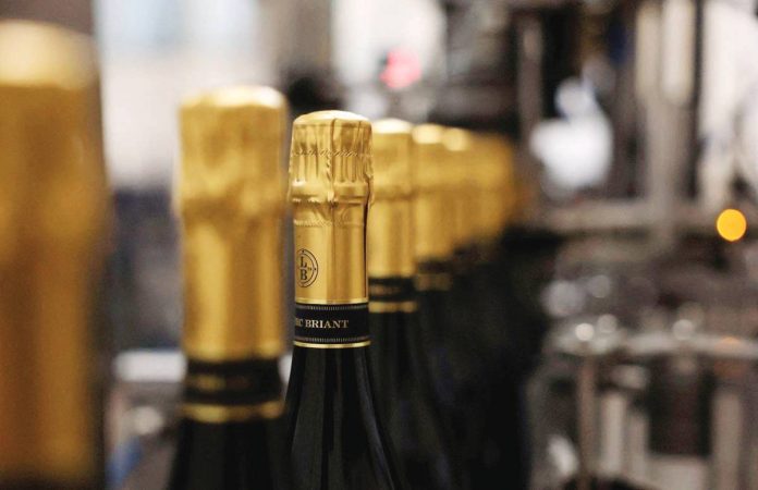 Champagne bottles are filled at a champagne house, in Epernay, France on August 22, 2025. REUTERS/CHRISTIAN HARTMANN/FILE PHOTO