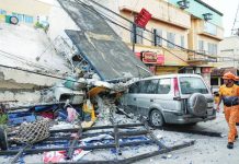 Firemen walk beside a collapsed building caused by a recent strong earthquake in Bogo Cty, Cebu Province. The Iloilo Provincial Government is extending financial assistance to earthquake victims in Cebu. AP PHOTO/AARON FAVILA
