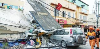 Firemen walk beside a collapsed building caused by a recent strong earthquake in Bogo Cty, Cebu Province. The Iloilo Provincial Government is extending financial assistance to earthquake victims in Cebu. AP PHOTO/AARON FAVILA