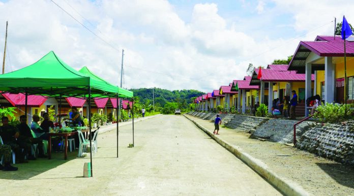 neljoy_NIA_housing_resized_compressed ROAD TO SUSTAINABLE FUTURE. On either side of this new concrete road are rows of new, low-cost housing units built for 32 Panay Bukidnon Indigenous Peoples (IP) families in Sitio Agburi, Barangay Cahigon, Calinog, Iloilo. Displaced by the construction of the Jalaur River Multi-Purpose Project Stage II, they were relocated to Sitio Agburi by the government. NIA-6 PHOTO