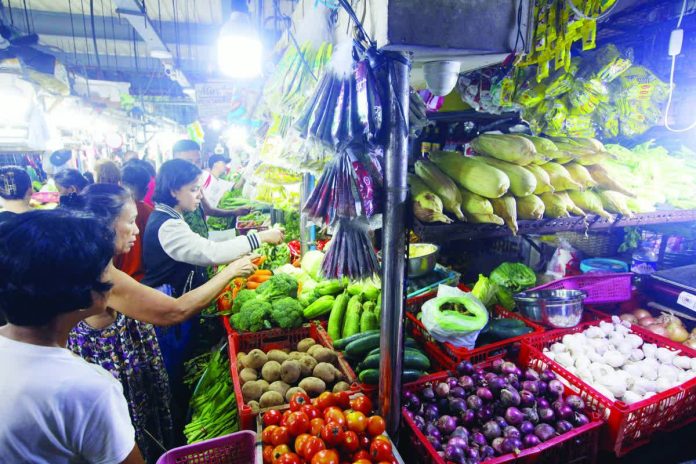 A vegetable stall inside the Paco Public Market in Manila is packed with marketgoers. The Department of Trade and Industry is poised to act against overpricing on basic and prime commodities to cushion consumers from rising costs ahead of the holiday rush. PNA