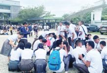 High school students huddle on the ground outside their school in Davao Oriental after feeling the magnitude 7.4 earthquake.