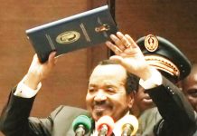 Paul Biya, 92, holds the swearing-in certificate above his head as president of Cameroon for the eighth consecutive time since 1982. MICHEL MVONDO / BBC