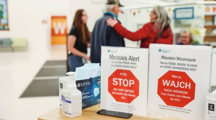 Canada People stand near healthy awareness posters related to the measles outbreak during a public health awareness campaign, at the Taber Health Centre, in the largely Mennonite community of Taber, Alberta, Canada. GETTY IMAGES