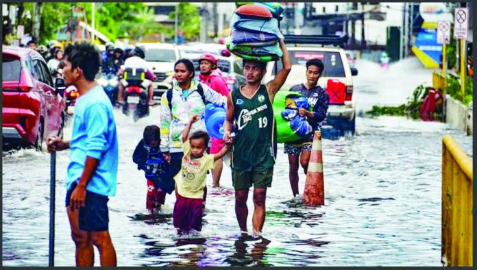 DILG_orders_copy_resized_compressed Residents carrying their belongings, wade through a flooded street in Mandaue City, Cebu province. They are assessing damage after Typhoon Tino. AFP VIA GETTY IMAGES