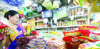 A store owner arranges noche buena food items at her stall at the Paco Public Market in Manila. The Department of Trade and Industry said prices of food products for noche buena have remained stable while others even decreased. PNA