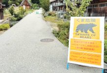Bear attacks rise in Japan; Gov’t plans to hire hunters A yellow sign propped on a road reads: “Beware of bears”. In the background are traditional Japanese wooden houses. GETTY IMAGES