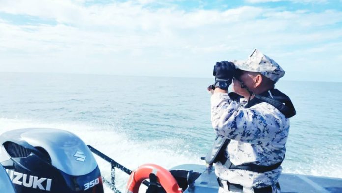 Malaysia A Malaysian Coast Guard official uses binoculars to search for survivors of a sunken boat. MALAYSIA COAST GUARD
