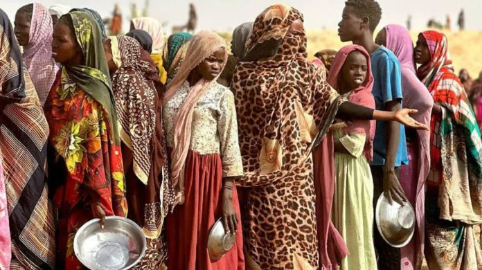 Sudan_compressed People who fled the Zamzam camp for the internally displaced after it fell under RSF control, queue for food rations in a makeshift encampment in an open field near the town of Tawila in war-torn Sudan's western Darfur region. AFP VIA GETTY IMAGES