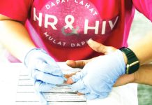 In this photo taken in 2019, an AIDS Society Philippines staff member offers HIV free testing at their booth set up at the public cemetery in Cainta, Rizal, during that year’s “Undas” commemoration. INQUIRER FILE PHOTO