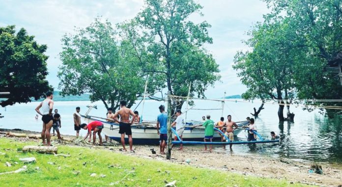 Fisherfolk from Barangay Nipa, San Dionisio, Iloilo are seen hauling their boats inland ahead of the expected landfall today of Typhoon Tino. JERLYN BATOGON FB PHOTO