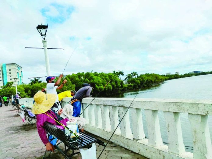 mai_river_anglers_copy_resized_compressed Anglers cast their lines along the Iloilo River Esplanade — an everyday routine for many – before the Iloilo City’s four-month fishing shutdown takes effect on December 1, 2025. PN FILE