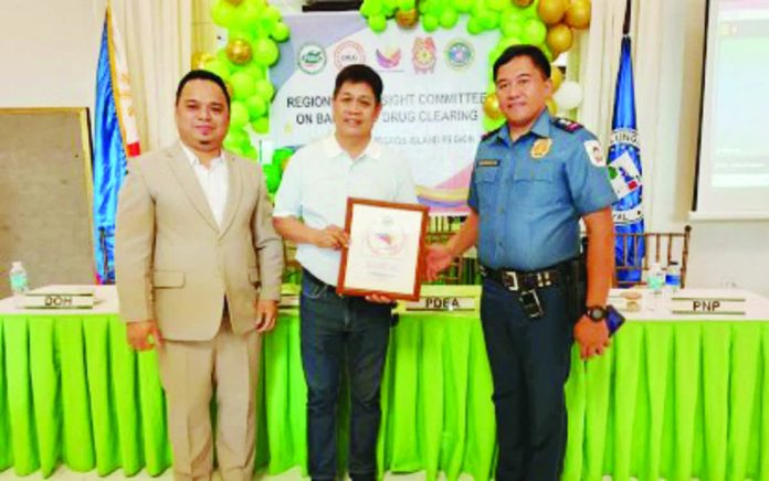 silay_drug_cleared_resized_compressed Philippine Drug Enforcement Agency-Negros Island Region acting Regional Director Melvin Estoque (left) awards the Balangay Seal of Excellence to Silay City’s Mayor Joedith Gallego and police chief Lt. Col. Mark Anthony Darroca during the Regional Oversight Committee on Barangay Drug Clearing deliberation held at the Golden Food Park on Nov. 26, 2025. PNA PHOTO BY NANETTE L. GUADALQUIVER
