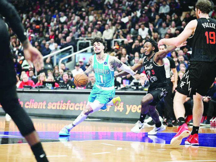 sports_Char_resized_compressed Charlotte Hornets' LaMelo Ball eludes the defense of Toronto Raptors guard Immnauel Quickley. PHOTO BY IMAGN IMAGES