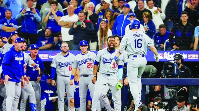 Will Smith celebrates with Los Angeles Dodgers teammates following his go-ahead homerun against Toronto Blue Jays. GETTY IMAGES