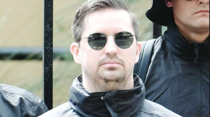 Matthew Gruter, seen among black-clad men at the protest, moved to Australia with his wife in 2022. The South African man has been taken into immigration detention after his visa was revoked. BBC
