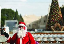 Bethlehem lights up Christmas tree for first time since start of Gaza war A man dressed as Santa Claus stands in Manger Square ahead of the lighting of the Christmas tree in the West Bank city of Bethlehem. EPA