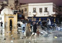 People wade through floodwaters in the old city center of Morroco. AFP VIA GETTY IMAGES