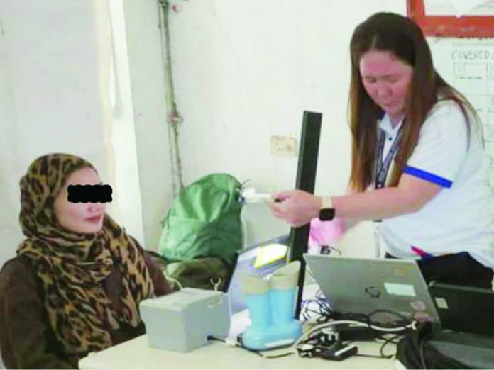 PSA_aklan_copy_resized_compressed A registration officer captures the front-facing photo of a registrant during the National ID registration at Manoc-Manoc Covered Court in Boracay, Malay, Aklan. PSA-AKLAN PHOTO