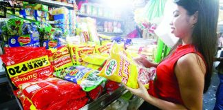 A woman checks spaghetti noodles and sauce packs sold at a stall inside the Paco Public Market in Manila on Dec. 2, 2025. The Department of Trade and Industry assured that prices of basic goods remain generally unchanged ahead of the Christmas holidays, stressing that monitoring will continue to ensure that retailers will not raise their prices to the detriment of the public. PNA