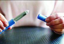 A medical professional holds two parts of a weight loss jab which looks like a pen with its lid off. GETTY IMAGES