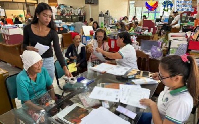 Representatives of 20 families affected by a recent fire in Barangay V, San Carlos City, Negros Occidental line up during the distribution activity held at the City Social Welfare and Development Office on Dec. 22, 2025. Each family received P30,000 in financial assistance from the National Housing Authority. PHOTO COURTESY OF NHA