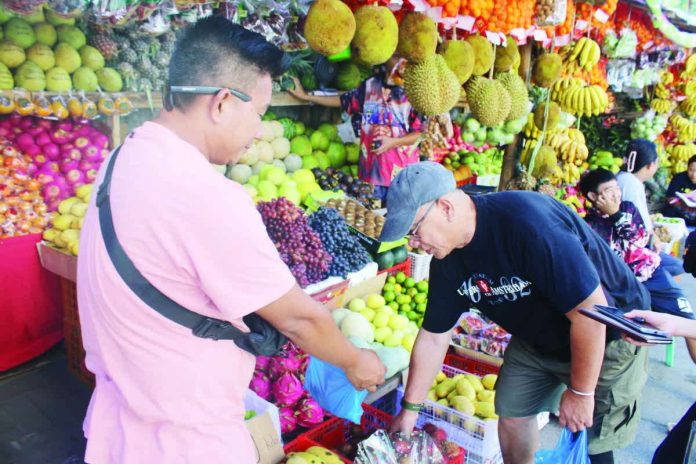 fruit_vendor_pic.JPG_resized_compressed “If we can’t sell everything, it’s no big deal. We keep pushing until the last fruit is sold, and if we need to, we give away the leftovers,” says Rogelio Lancita Jr. (left) from Barangay San Isidro, Jaro, Iloilo City. Lancita has been selling fruits for over 15 years. AJ PALCULLO/PN