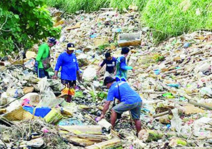 mai dumping copy_compressed Iloilo City Hall workers and community volunteers wade through mounds of mixed waste — including refrigerator casings and suspected junk shop discards — during a cleanup at a tributary of the Jaro River in Barangay Cubay, Jaro, Iloilo City. Authorities say the volume and type of trash point to possible illegal dumping, which threatens to obstruct waterways and worsen flooding in surrounding communities. GSO PHOTO
