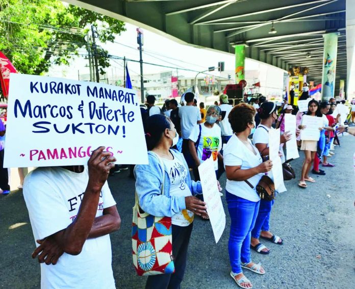 Activists gather under the Infante Flyover in Iloilo City, carrying placards condemning corruption and calling for accountability from President Ferdinand Marcos Jr. and Vice President Sara Duterte-Carpio during the commemoration of the International Human Rights Day. NELJOY GALIGAO/PN