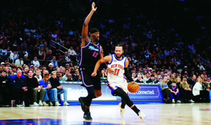 New York Knicks guard Jalen Brunson (11) dribbles around Miami Heat center Bam Adubayo (13) during the first half of an NBA basketball game Sunday, Dec. 21, 2025, in New York. AP