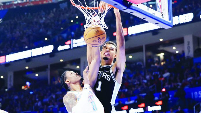 San Antonio Spurs center Victor Wembanyama dunks over the defense of Oklahoma City Thunder's Jalen Williams. NBA PHOTO