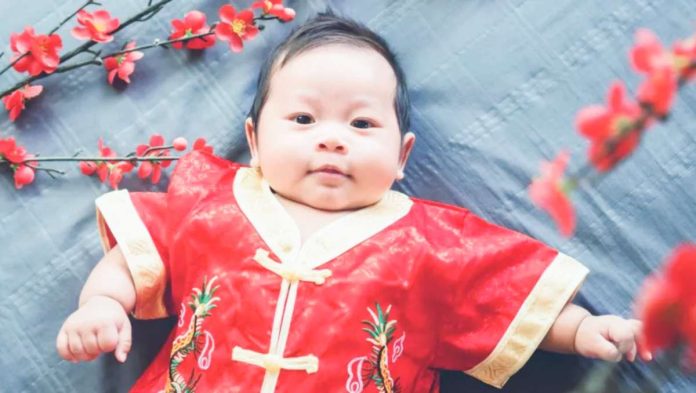 China A baby is dressed in a traditional Chinese outfit. Young couples in China, like elsewhere, are having fewer or no children. GETTY IMAGES