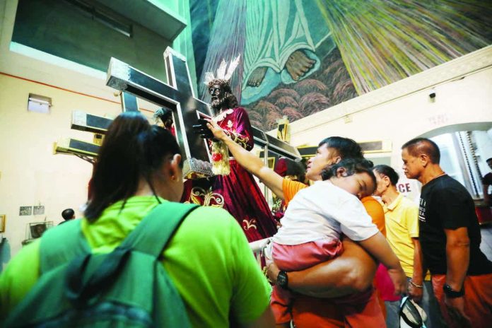 DOH_warns_resized_compressed A devotee touches an image of Jesus Nazareno at Quiapo Church in Manila on Jan. 7, 2026, two days before the annual Traslacion. Millions are expected to attend the Nazareno feast on Jan. 9. PNA