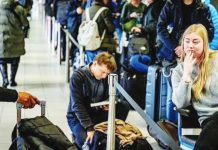 6 dead, hundreds of flights cancelled as snow causes chaos across Europe Travellers queue with their luggage at Schiphol Airport. One woman is sitting with her phone in her hand, while a man behind her is kneeling next to his bag while reading a book. Hundreds of people were stranded at Amsterdam airport. GETTY IMAGES