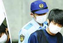 Tetsuya Yamagami, suspected of killing former Japanese Prime Minister Shinzo Abe, is escorted by a police officer as he is taken to prosecutors, at a police station in Nara. REUTERS