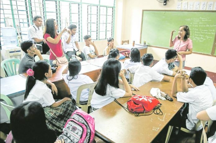 A teacher at Ramon Magsaysay (Cubao) High School in Quezon City listens to concerns raised by her students during the start of classes in this photo taken in 2018. INQUIRER PHOTO