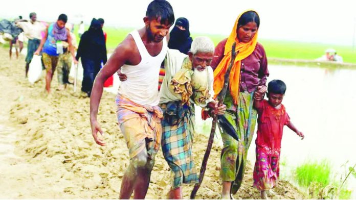 Myanmar_copy_resized_compressed Rohingya refugees walk on the muddy path after crossing the Bangladesh-Myanmar border in Teknaf, Bangladesh. Hundreds of thousands of Rohingya people fled Myanmar during an army crackdown in 2017. REUTERS
