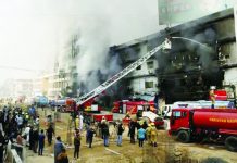 At least 21 dead, dozens missing in Pakistan mall fire Smoke rises as firefighters spray water to extinguish a massive fire that broke out in the Gul Plaza Shopping Center building, in Karachi, Pakistan. REUTERS