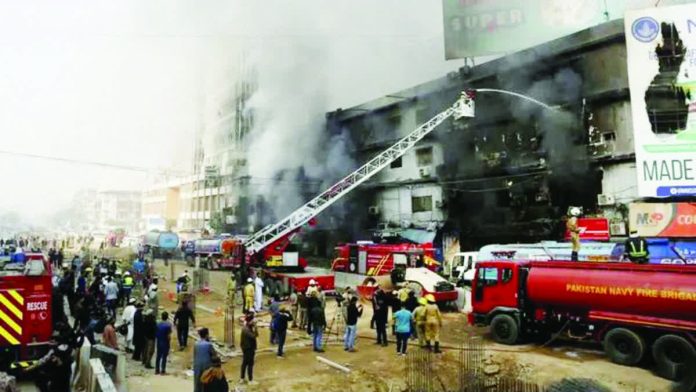 Pakistan_copy_resized_compressed Smoke rises as firefighters spray water to extinguish a massive fire that broke out in the Gul Plaza Shopping Center building, in Karachi, Pakistan. REUTERS