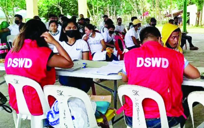 Personnel of the Department of Social Welfare and Development distributes Assistance to Individuals in Crisis Situations (AICS) in this undated photo. A provision in the proposed 2026 national budget bars elected officials from any role in the release or distribution of government assistance — whether in cash or in kind. PNA