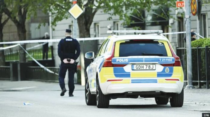 Swedish officer walks near a police car. Sweden plans to lower the age of criminal responsibility from 15 to 13 as it grapples with a growing number of children recruited into gangs to carry out violent crimes. EPA