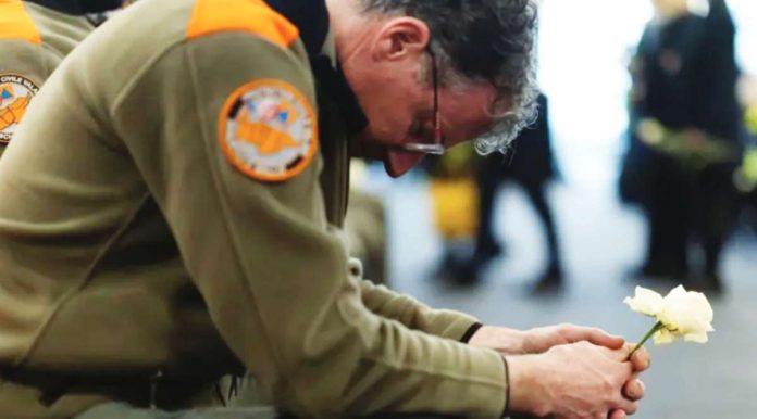The community in Crans-Montana in Switzerland remains in shock two weeks after a New Year’s Eve fire killed 40 people. Photo shows a bespectacled member of the civil protection unit holding a white rose. EPA