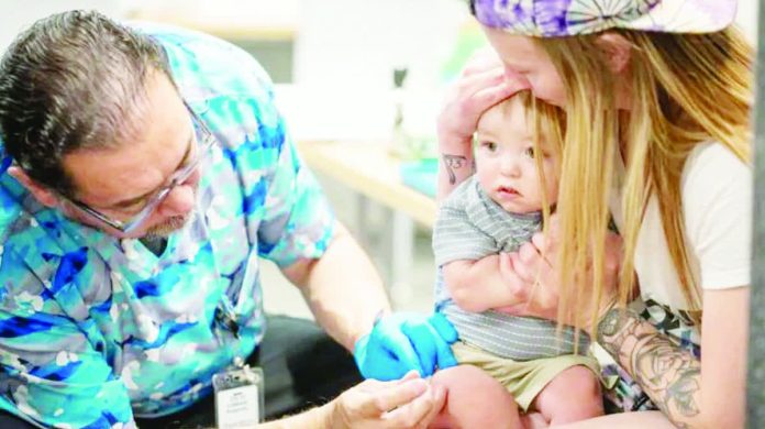 US_copy_resized_compressed A one-year-old is held by his mother while he receives an MMR vaccine at a clinic in Texas. Vaccination rates have fallen in the United States, leading to more measles outbreaks. GETTY IMAGES