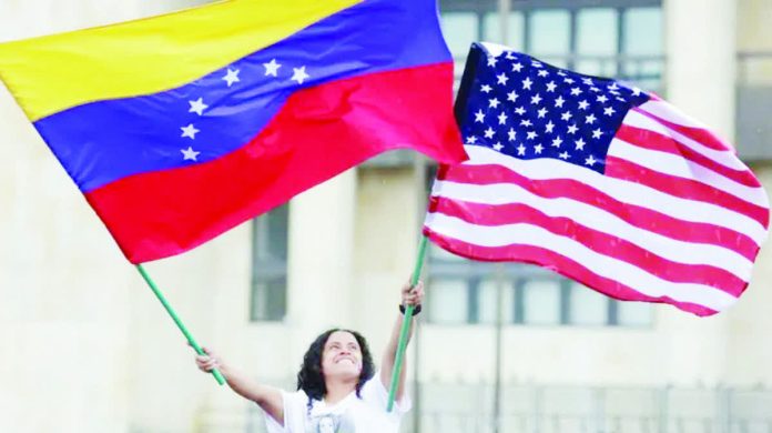 Venezuela_resized_compressed A Venezuelan living in Colombia waves a Venezuelan flag and a US flag at Plaza de Bolivar, in Bogota. REUTERS