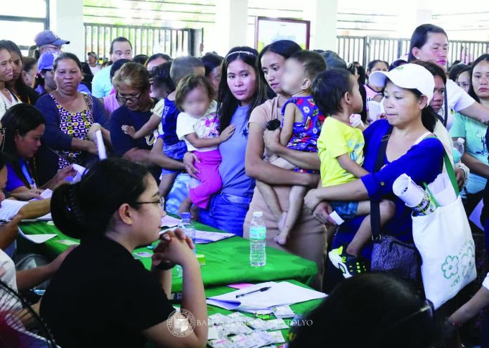 aics_pic_resized_compressed Residents of Carles, Iloilo line up with their children to receive financial assistance under the Assistance to Individuals in Crisis Situations (AICS) program in this file photo. The Department of Social Welfare and Development - Region 6 says beneficiaries can now directly seek aid from DSWD satellite and extension offices, eliminating the need to go through political channels as part of reforms to improve transparency and access. BALITA HALIN SA KAPITOLYO PHOTO