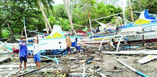 Fisherfolk inspect damaged pump boats strewn along the shoreline of Barangay Igbon, Concepcion, Iloilo after strong waves battered the coastal village over the weekend, destroying and damaging dozens of fishing vessels — the primary source of livelihood and transport for residents. PHOTO CONTRIBUTED BY AIROSE C. CALINAO