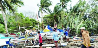 AFTERMATH OF THE WAVES. Fishermen inspect and salvage damaged fishing boats along the coastline of Concepcion, Iloilo after strong waves battered the area over the weekend, leaving hundreds of boats wrecked or partially destroyed and disrupting the livelihood and transport of island communities. PHOTO CONTRIBUTED BY AIROSE C. CALINAO